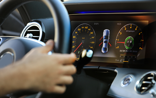 image of hand on black steering wheel