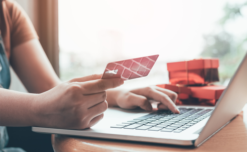 Woman checking card information on laptop