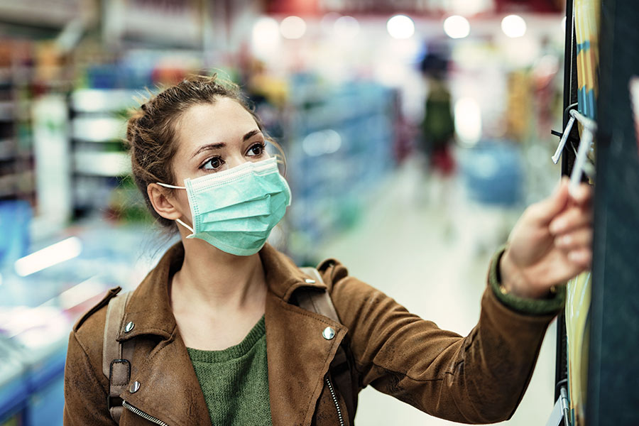 young woman wearing a mask while shopping during COVID-19