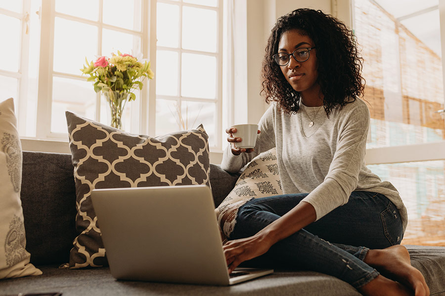 young woman working on her laptop while drinking coffee