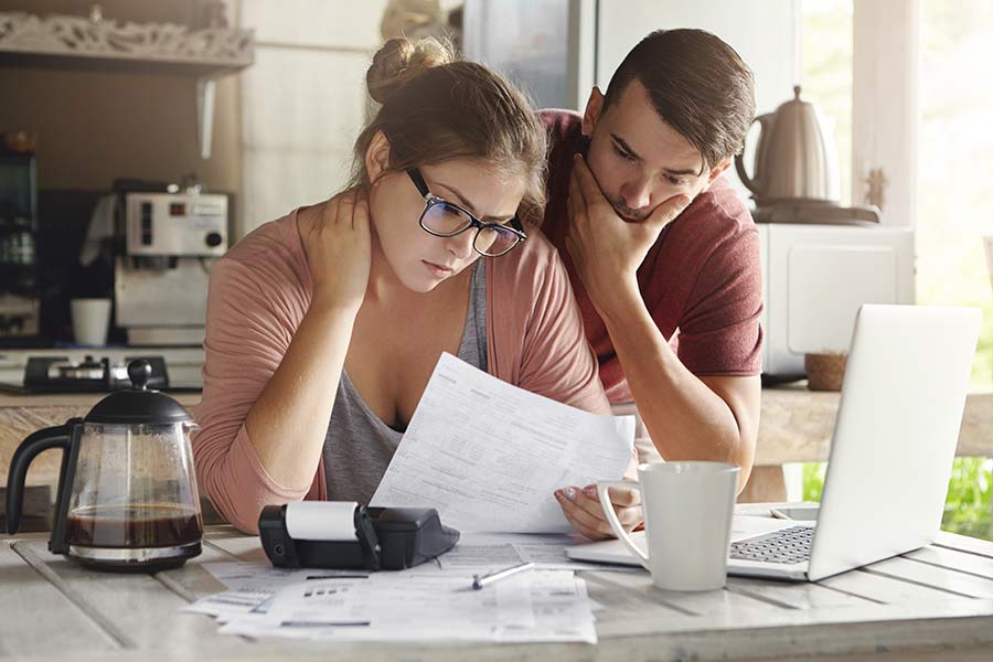 Couple developing a plan to pay off their debt. Learn the 3 best ways to pay off debt quickly.