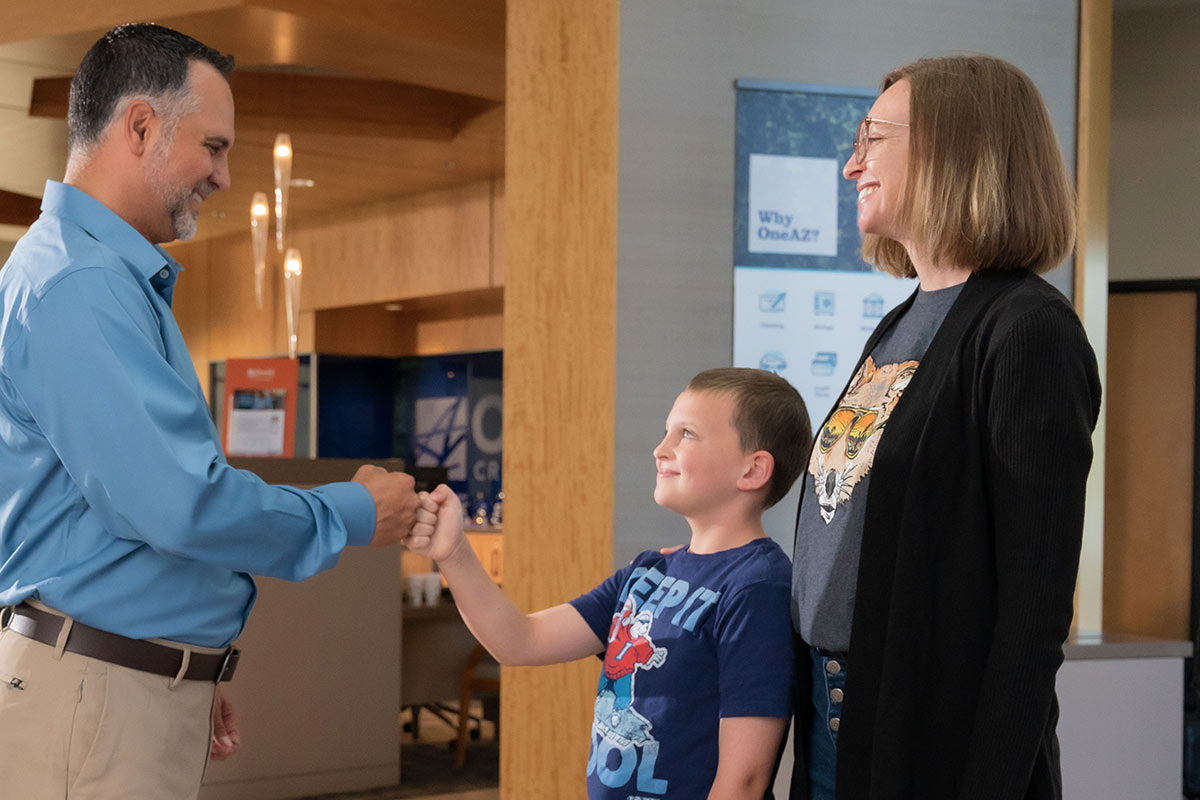 Mom introducing her son to a banker at OneAZ Credit Union.