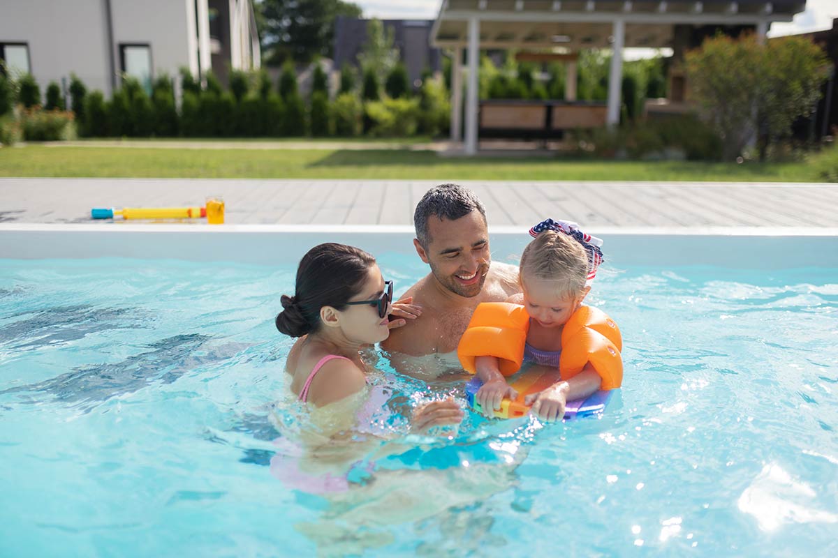 family enjoying backyard pool together